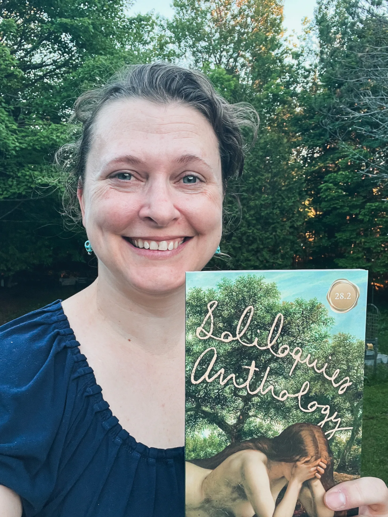 Woman holding book, smiling.